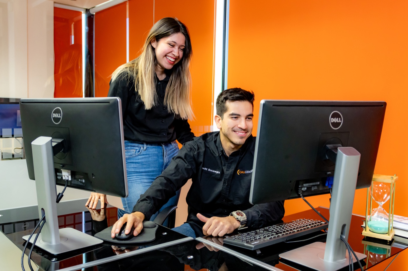 Two CallCentered colleagues collaborating at a dual-monitor workstation in Hermosillo